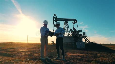 Dos Trabajadores Petroleros Dándole La Mano En Un Campo Petrolero