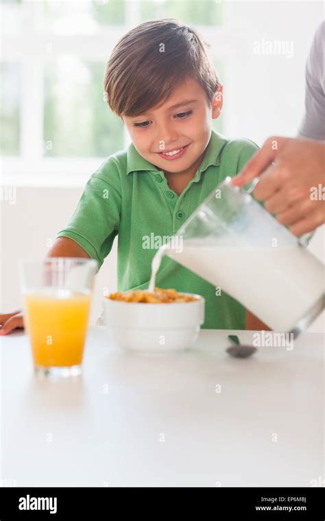 Father Pouring Milk In The Cereal Of His Son Stock Photo Alamy