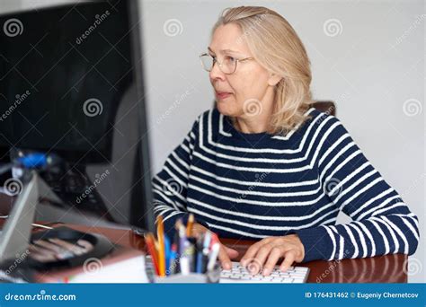 Mature Middle Aged In Glasses Using Laptop Typing Email Working At Home