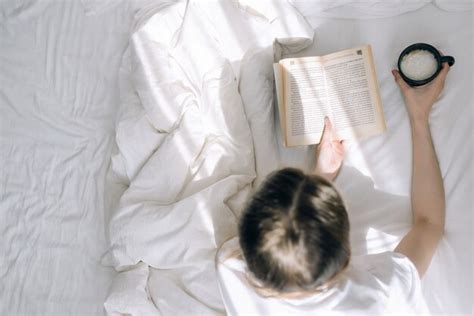 Vista Superior De La Mujer Joven Leyendo Un Libro Y Sosteniendo Una