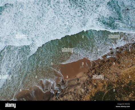 Aerial View To Ocean Waves And Rocks In A Beach Blue Water Background