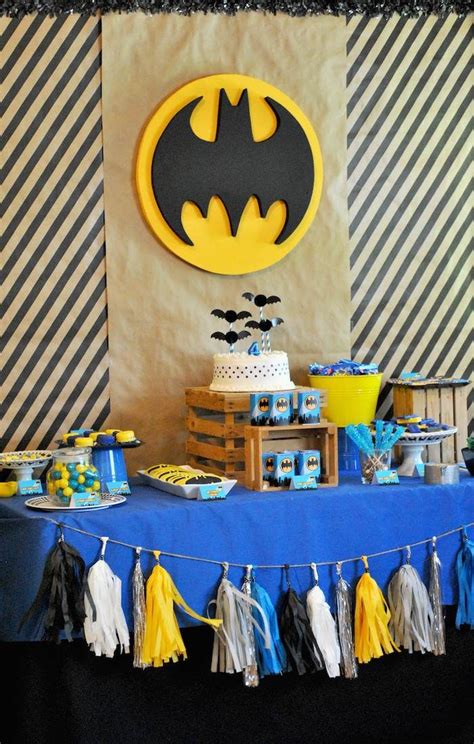 A Batman Themed Birthday Party With Blue And Yellow Dessert Table Cloths Tissue Pom Poms And Cake