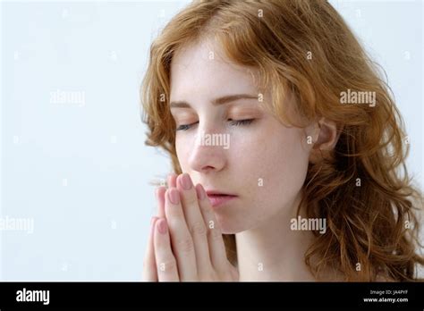 A Red Haired Girl With Curls Folded Her Hands In Prayer And Closed Her