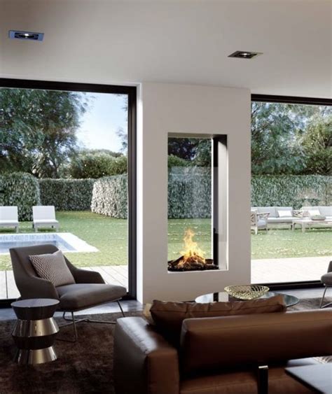 A Modern Living Room With Large Windows And A Fire Place In The Middle