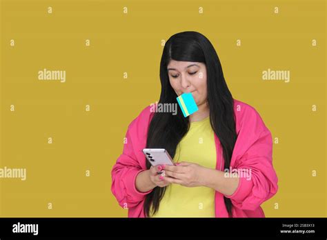 Year Old Latina Woman Uses Her Credit Card And Cell Phone To Make Purchases And Payments
