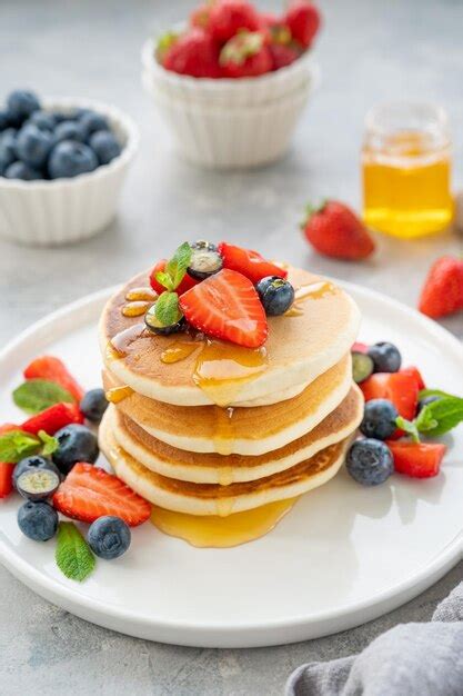 Uma Pilha De Deliciosas Panquecas Fofas Frutas E Mel Em Um Prato