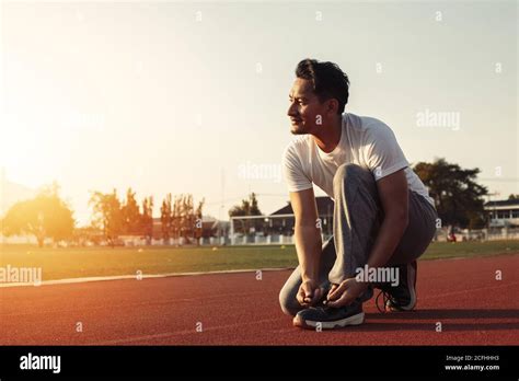 Attractive Brunette Man Tie Him Sport Shoes On Track Race A Man At
