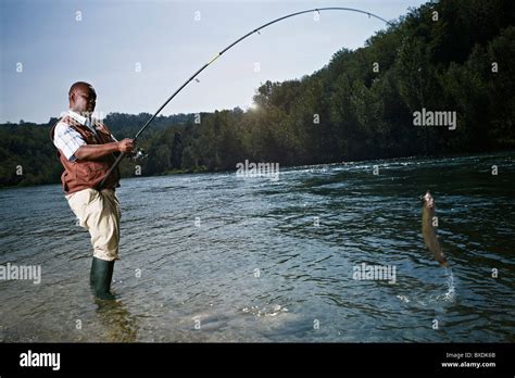 Black Man Catching Fish In Stream Stock Photo Alamy