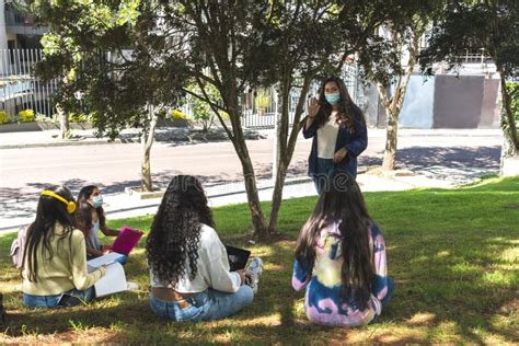 A Latina Teacher Points Her Index Finger At A Student To Give Her The Floor During An Outdoor