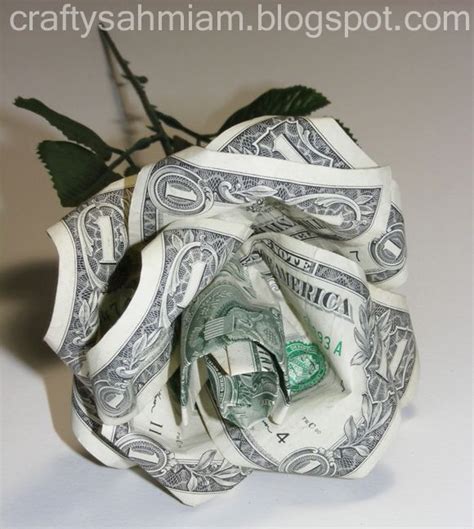 A Dollar Bill Origami Rose With Green Leaves On It S Stem Sitting On A