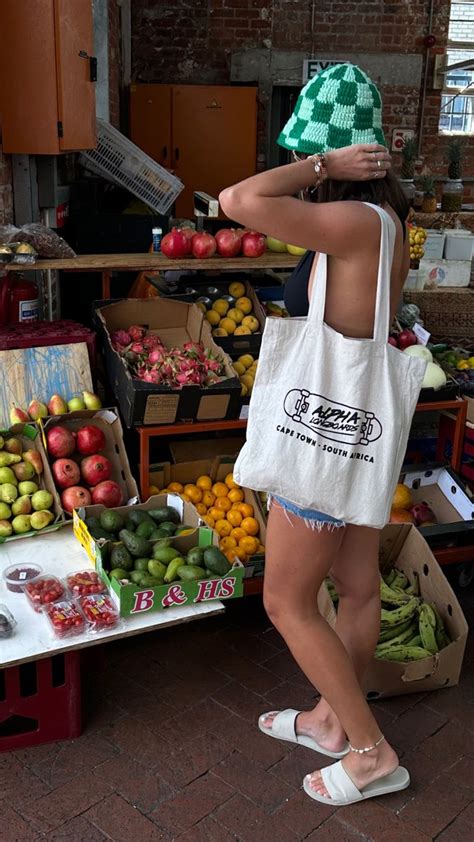 A Woman Standing In Front Of A Fruit Stand