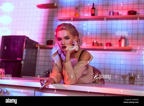 Beautiful Elegant Woman Leaning Over Kitchen Counter Looking At Camera