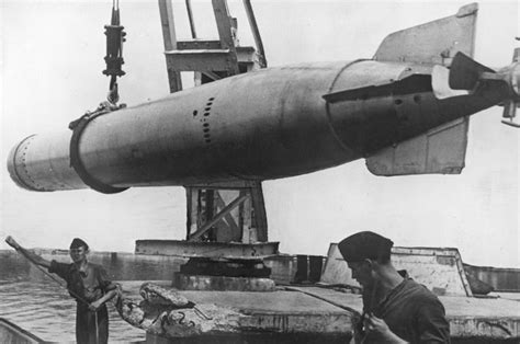 Немецкие моряки загружают торпеду на базе подводных лодок Кригсмарине ...