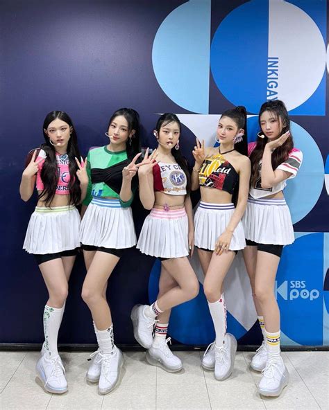 The Girls Are Posing In Front Of A Blue And White Wall With Their Hands Up