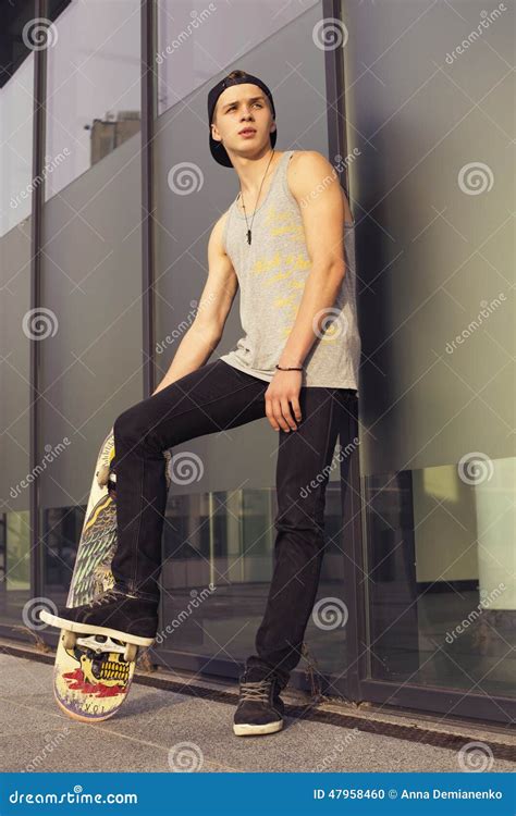 Young Blonde Guy On Skateboard In Casual Outfit In The Urban Cit Stock