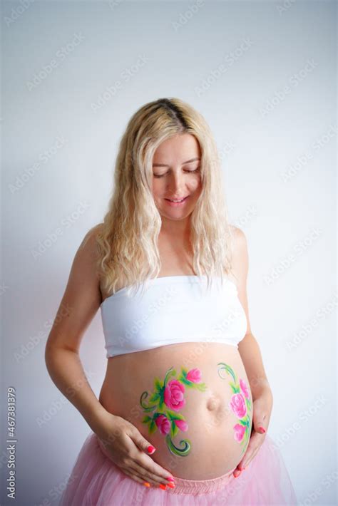 The Belly Of A Pregnant Blonde Woman On A Light Background The Girl