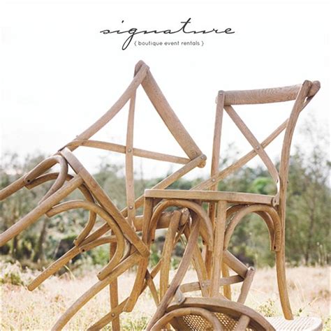 Three Wooden Chairs Sitting On Top Of A Grass Covered Field