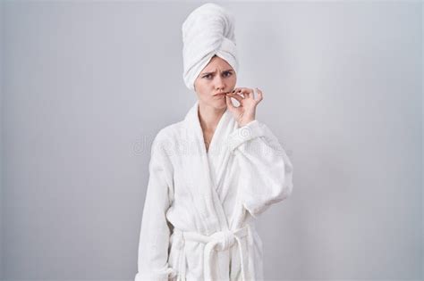 Blonde Caucasian Woman Wearing Bathrobe Mouth And Lips Shut As Zip With Fingers Stock Image