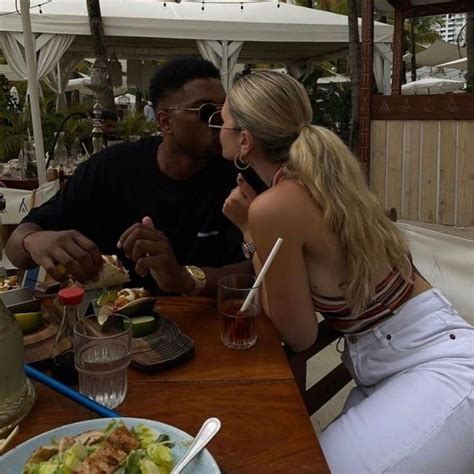 Two People Sitting At A Table Eating Food