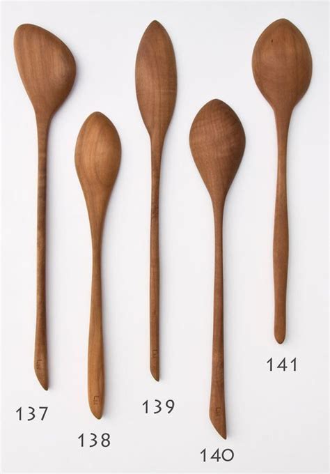 Four Wooden Spoons Are Shown Next To Each Other On A White Surface With