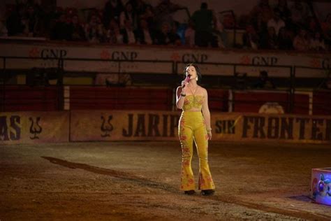 A Woman In Yellow Outfit Standing On Top Of A Dirt Field