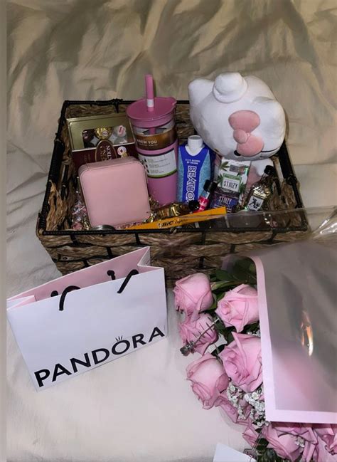 A Basket Filled With Pink Flowers Next To A White Bag And Some Other