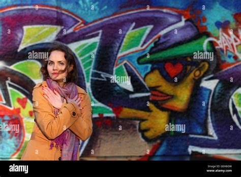 Beautiful Brunette Woman Standing In Front Of A Graffiti About Love Stock Photo Alamy