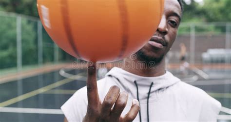 Sports Man Spinning A Basketball On His Finger While Standing In The