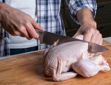 Un Cocinero Macho Corta Pollo Casero Fresco En Una Tabla De Madera