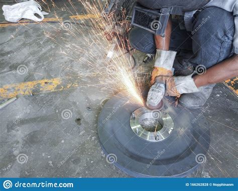 Worker Grinding And Cutting Steel Plate With A Lot Of Spark Stock Photo