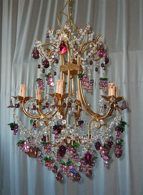 A Gold Chandelier With Pink And Green Crystals Hanging From It S Sides