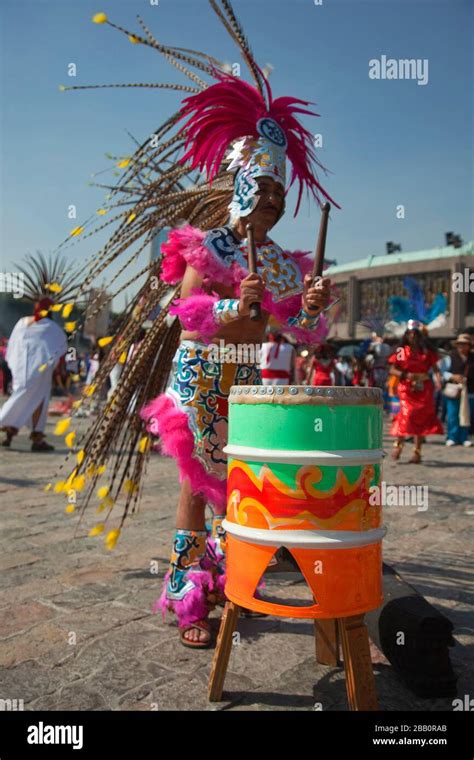 Indigenous Dancer In Traditional Costumes Playing Percussion During The