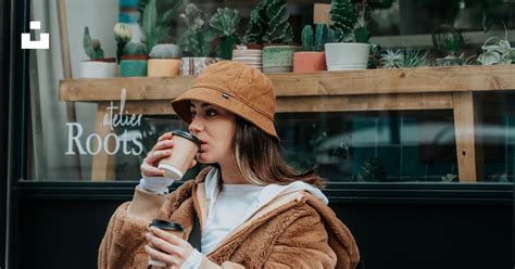 Femme En Manteau Marron Tenant Une Tasse En Céramique Blanche Photo