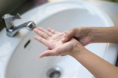 Premium Photo A Woman Washes Her Hands With Soap