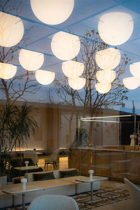 The Interior Of A Modern Office Building With Round Lights Hanging From