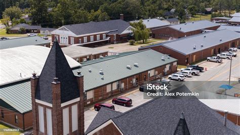 Onestory School Buildings With Parking Lots Stretching Behind The First