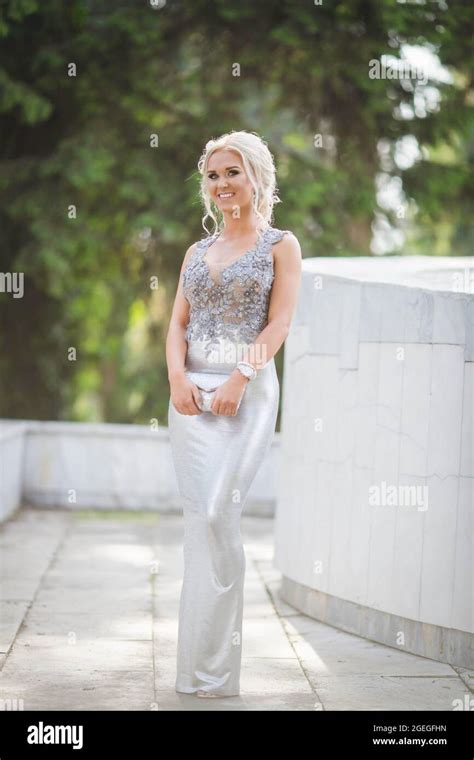 Attractive Blonde Lad Wearing A Long Silver Dress Is Posing Outdoors Stock Photo Alamy