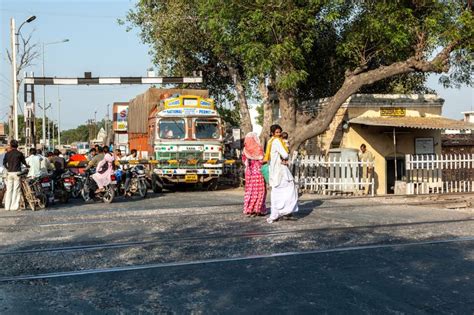 People At A Train Crossing Wait For The Passing Train To Continue