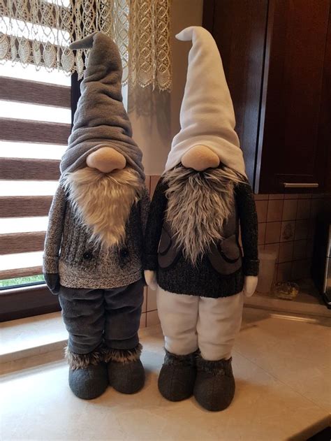 Two Gnomes Standing Next To Each Other In Front Of A Window