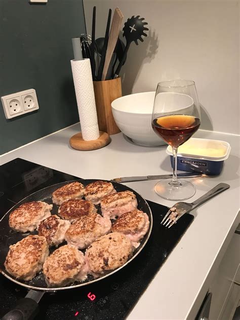 A Pan Filled With Food Sitting On Top Of A Stove Next To A Glass Of Wine