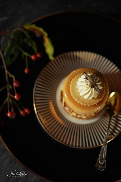 A Dessert On A Black Plate With Gold Spoons