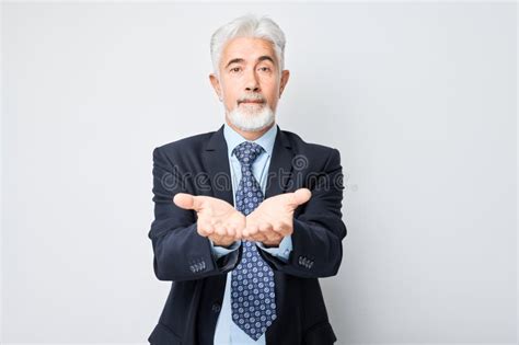 Gray Haired Mature Man 60 Years Old In Business Suit Holding Something