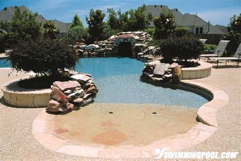 An Outdoor Swimming Pool Surrounded By Rocks And Trees