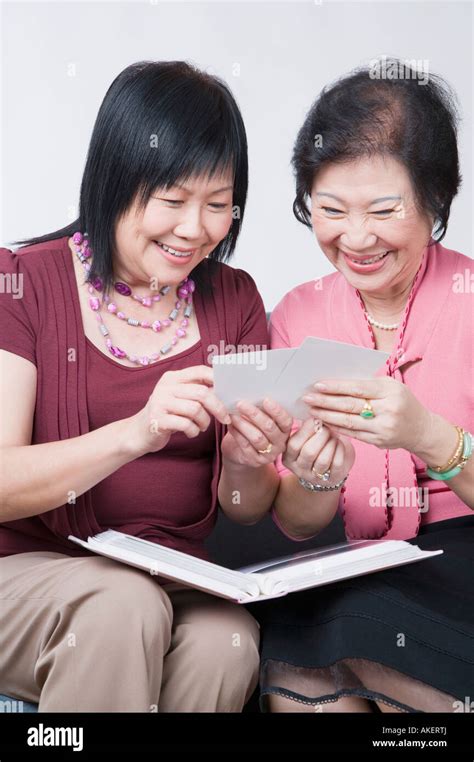 Close Up Of A Mature Woman And A Senior Woman Looking At Photographs