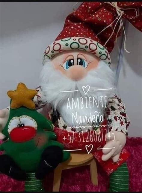 A Santa Clause Doll Sitting On Top Of A Chair Next To A Small Christmas