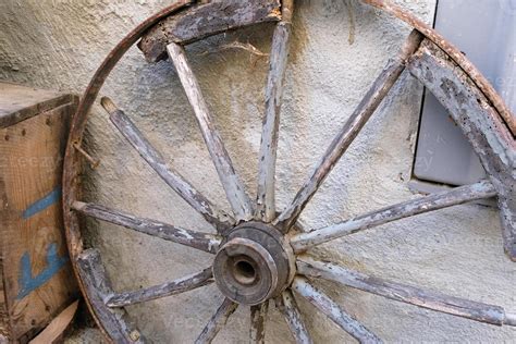 roda de carroça velha em um celeiro uma roda de carruagem de madeira