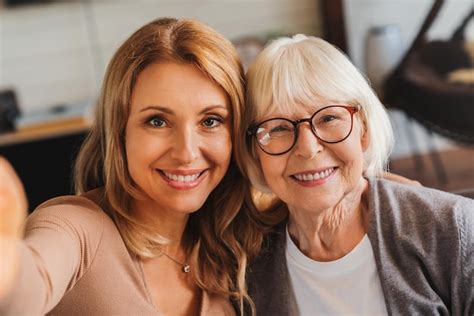 Femme G E Assise Avec Sa Fille Sur Un Canap Et Prenant Un Selfie Avec