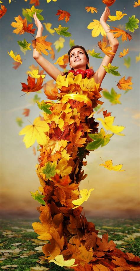 A Woman With Her Arms In The Air Surrounded By Leaves