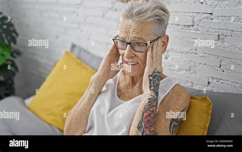 Stressed Grey Haired Senior Woman Suffering From A Headache Sitting On