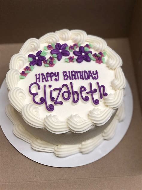 A Birthday Cake With White Frosting And Purple Flowers On The Top That Says Happy Birthday Elizabeth